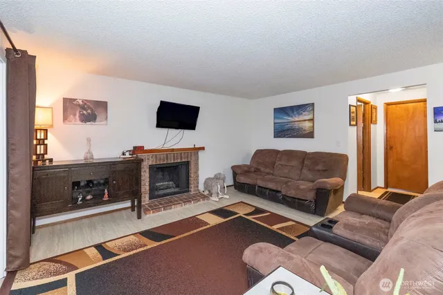 a living room with furniture a flat screen tv and a fireplace