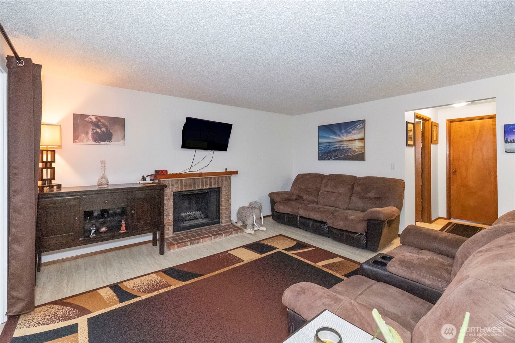 3400 Narrows View Lane Northeast, Unit 204 Bremerton, WA 98310 - Photo 8 of 38 a living room with furniture a flat screen tv and a fireplace