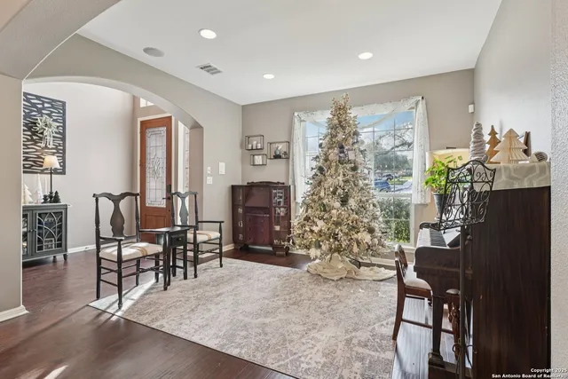 a dining room with wooden floor a chandelier a wooden table and chairs