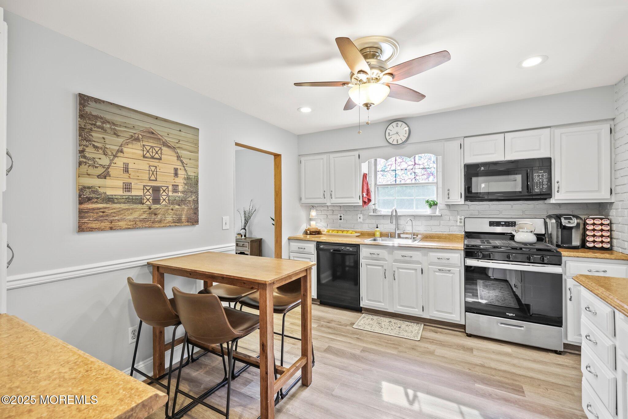 342 Diamond Road Jackson, NJ 08527 - Photo 18 of 30 a kitchen with stainless steel appliances granite countertop a stove a sink dishwasher a dining table and chairs with wooden floor