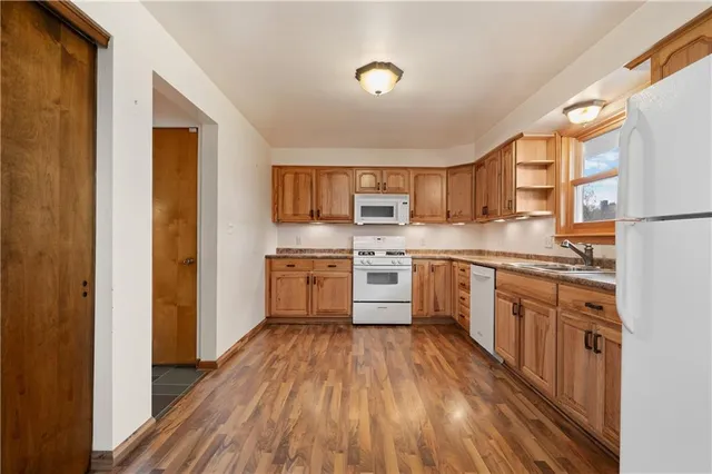 a kitchen with a sink a counter top space stainless steel appliances and cabinets