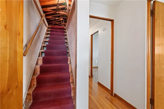 a view of a hallway with wooden floor and stairs