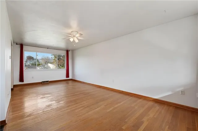 wooden floor in an empty room with a window