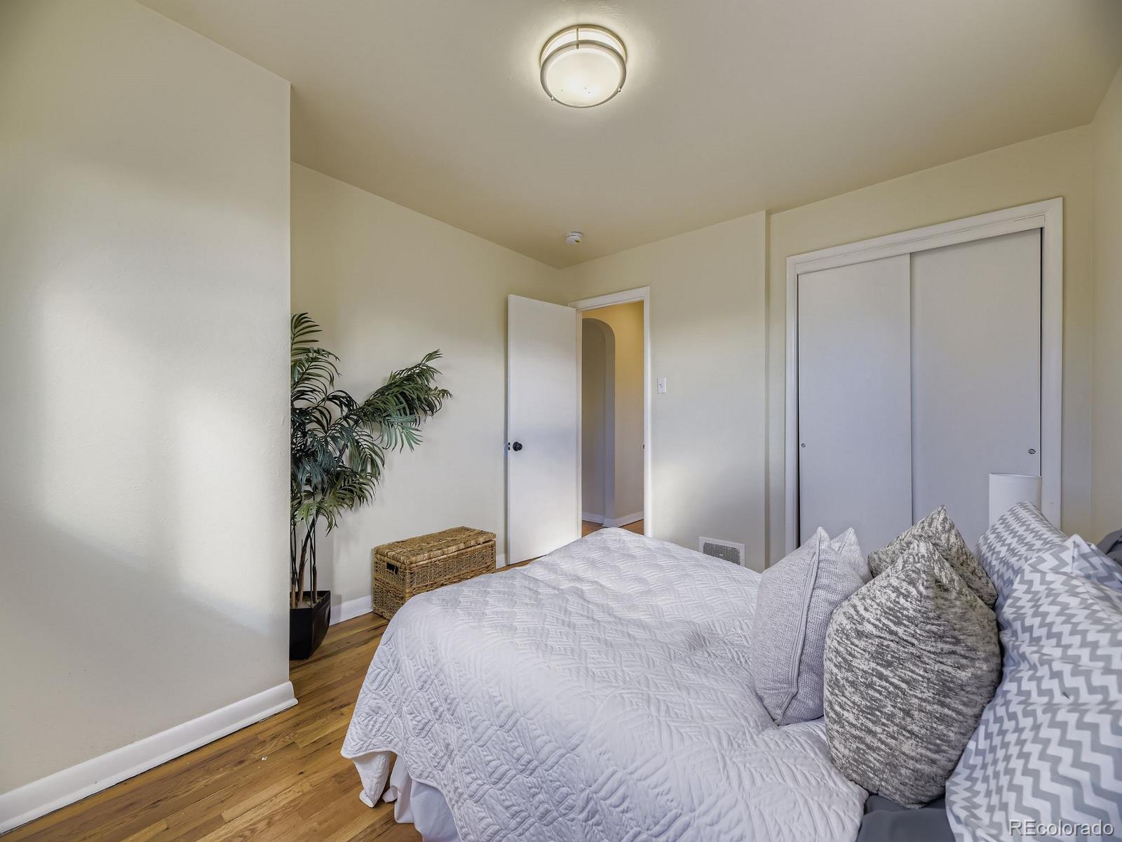 3820 Pierce Street Wheat Ridge, CO 80033 - Photo 11 of 32 a bedroom with a bed and a potted plant