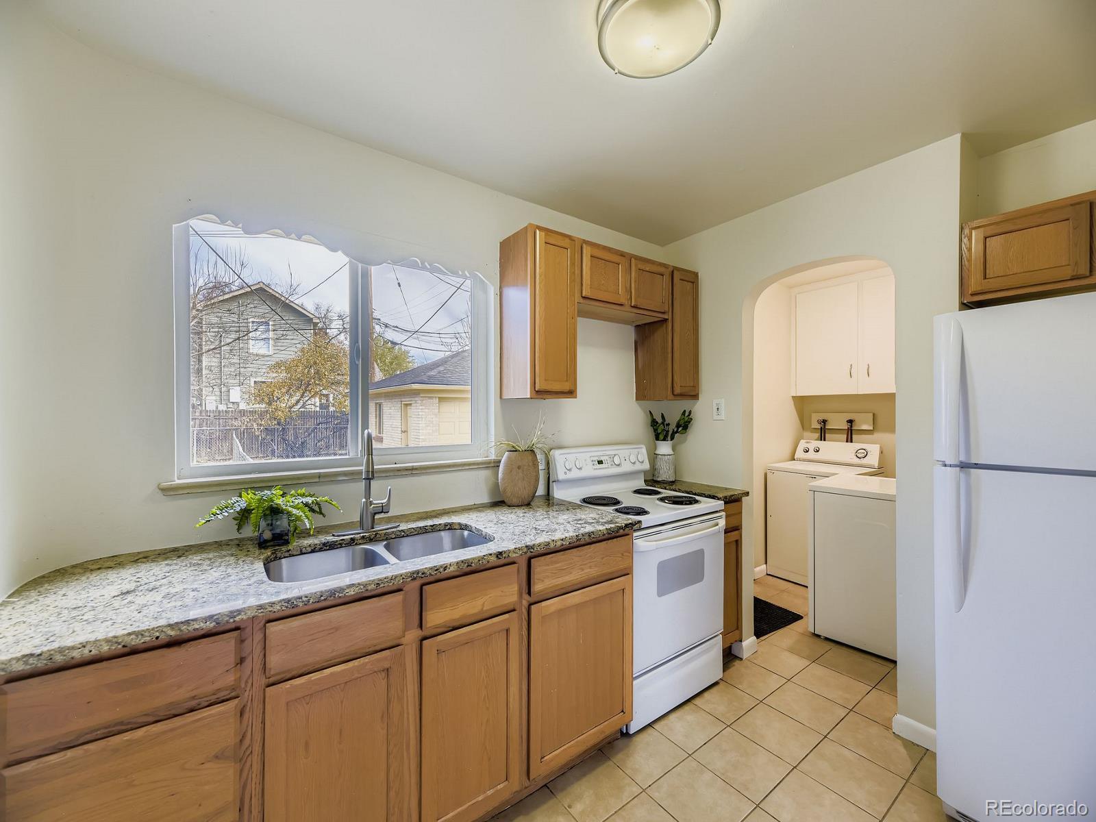 3820 Pierce Street Wheat Ridge, CO 80033 - Photo 12 of 32 a kitchen with a sink stove and refrigerator