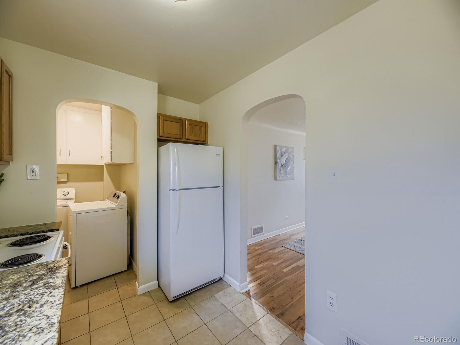 3820 Pierce Street Wheat Ridge, CO 80033 - Photo 15 of 32 a room with a refrigerator and a stove