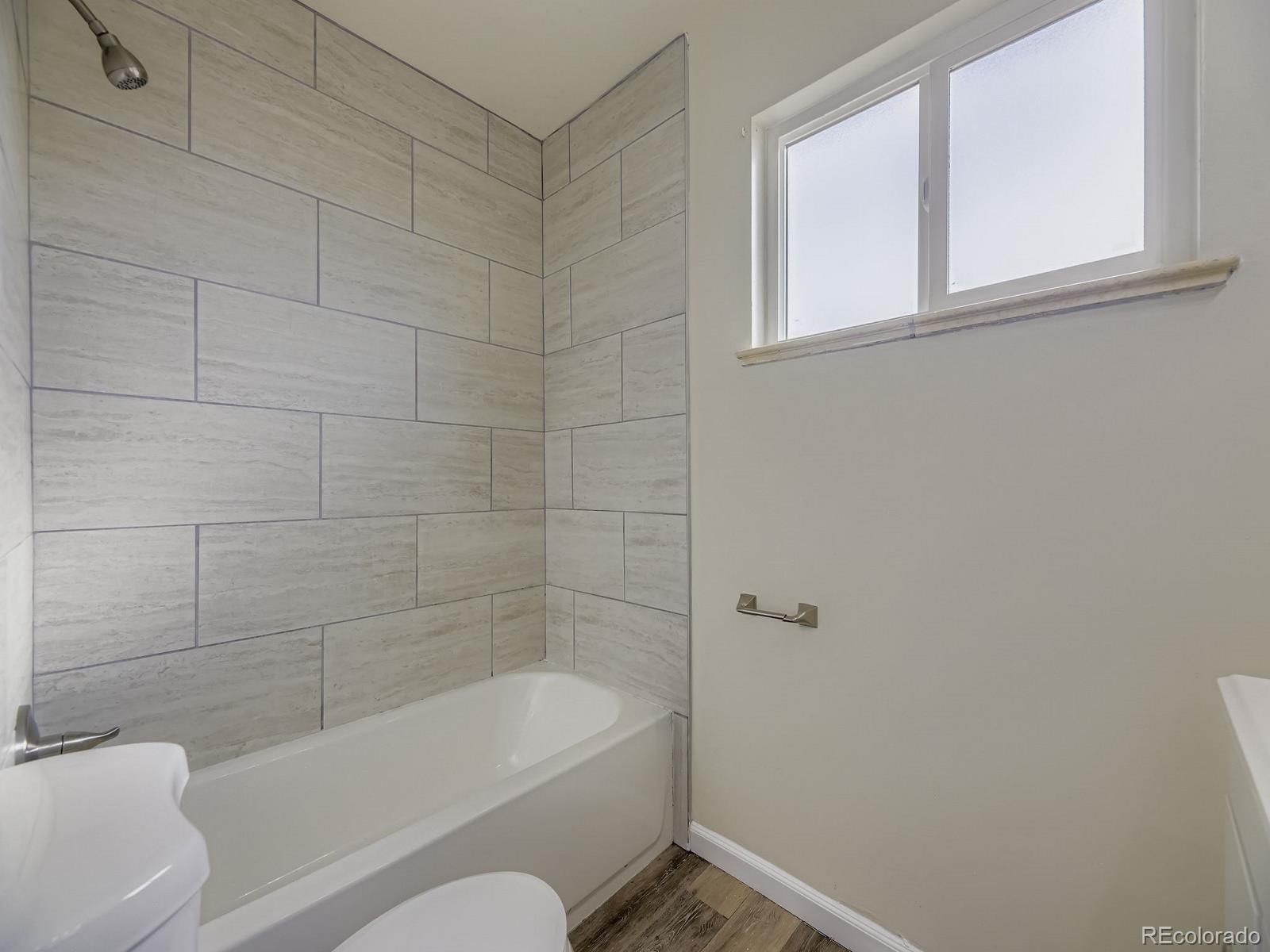 3820 Pierce Street Wheat Ridge, CO 80033 - Photo 23 of 32 a bathroom with a bathtub and window