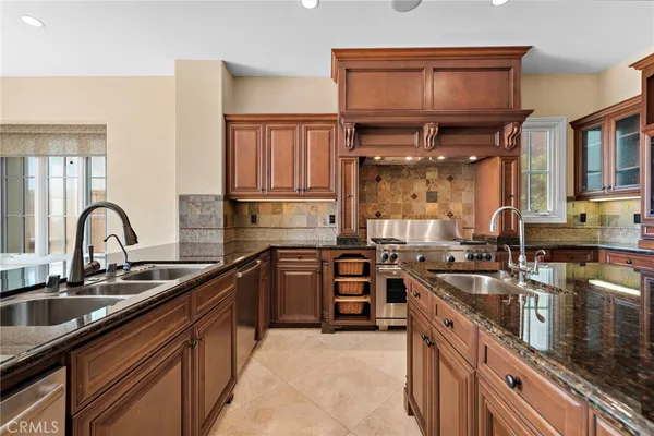 a kitchen with stainless steel appliances granite countertop a sink stove and cabinets