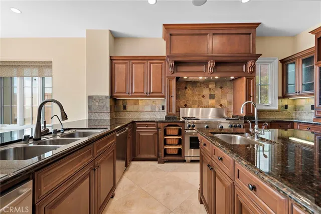a kitchen with stainless steel appliances granite countertop a sink stove and cabinets