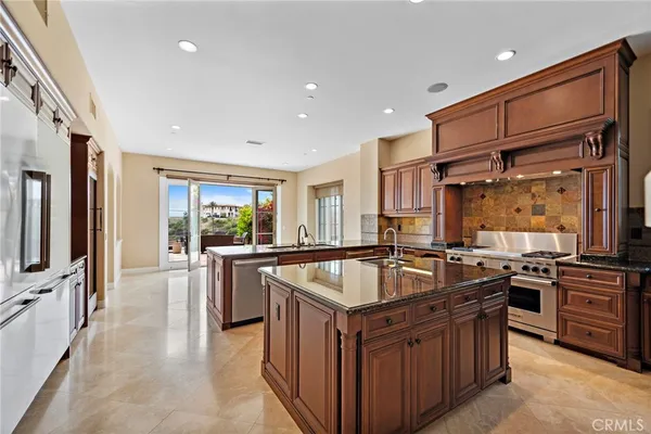 a kitchen with granite countertop a sink stove and refrigerator