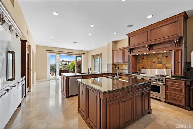 a kitchen with granite countertop a sink stove and refrigerator