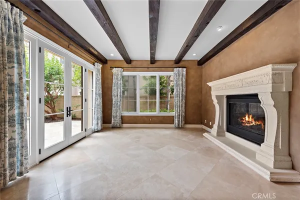 a view of an empty room with windows and a fireplace