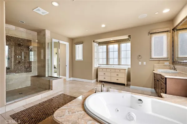a bathroom with a tub sink and mirror