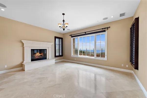 a view of an empty room with a fireplace and a window