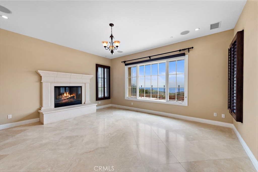 27 Pacific Mist Newport Coast, CA 92657 - Photo 6 of 44 a view of an empty room with a fireplace and a window