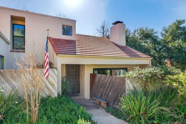 a front view of a house with entryway and plants