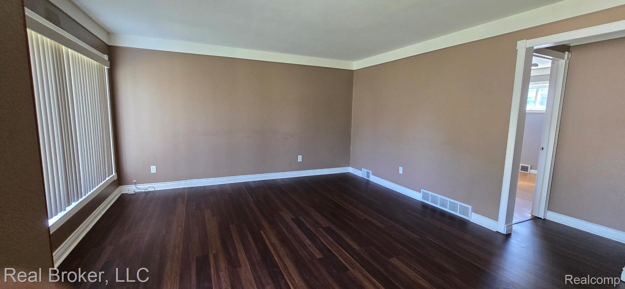 23401 Filmore Street Taylor, MI 48180 - Photo 5 of 16 Spacious interior featuring wood-finish flooring, neutral-toned walls, white crown molding, and white baseboards