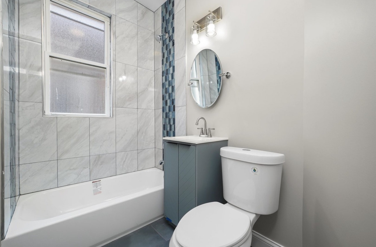 7548 South Harvard Avenue, Unit 2 Chicago, IL 60620 - Photo 2 of 7 a bathroom with a toilet a sink and bathtub