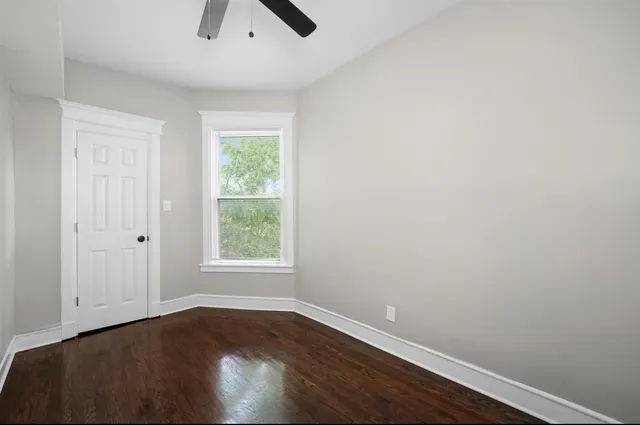 an empty room with a window and wooden floor