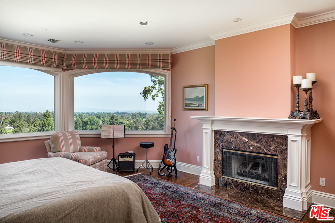 150 Patrician Way Pasadena, CA 91105 - Photo 17 of 43 a bedroom with a bed a table and a fireplace