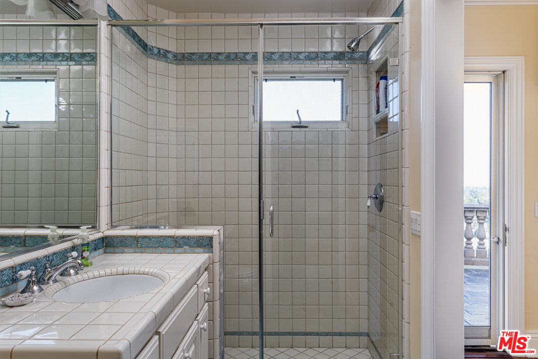 150 Patrician Way Pasadena, CA 91105 - Photo 26 of 43 a bathroom with a granite countertop shower a mirror and a sink