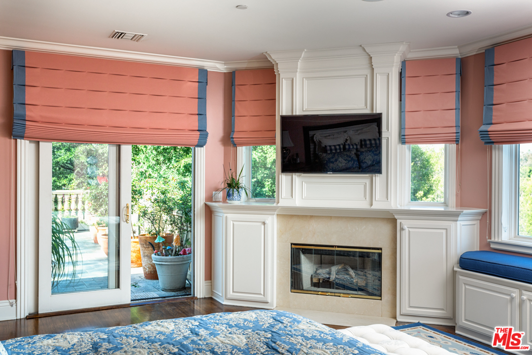 150 Patrician Way Pasadena, CA 91105 - Photo 32 of 43 a living room with a fireplace a flat screen tv and a window