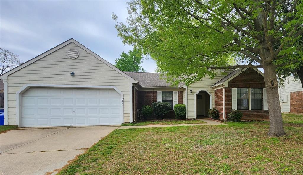 a view of a house with a yard and large tree