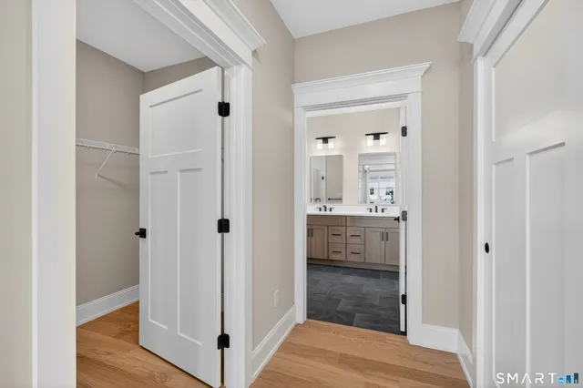 a view of a hallway with wooden floor and closet