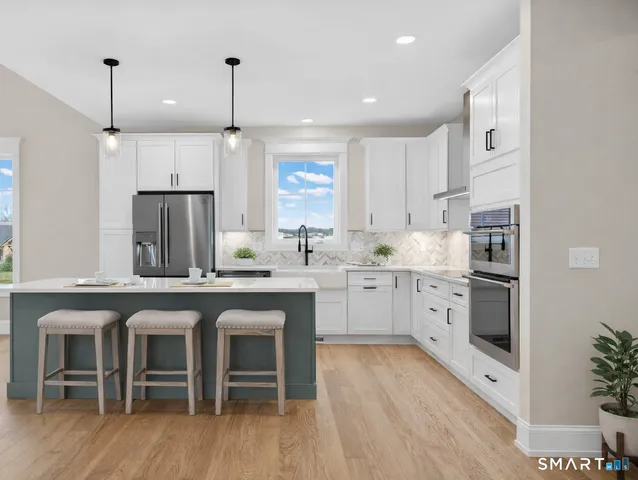 a kitchen with granite countertop white cabinets and refrigerator