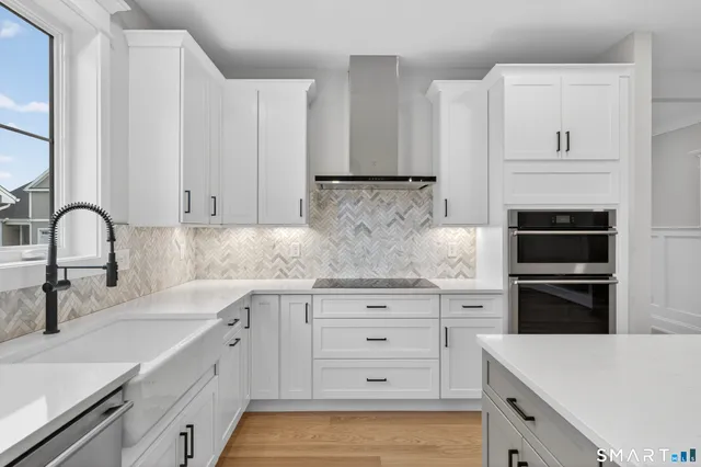 a kitchen with granite countertop white cabinets and stainless steel appliances