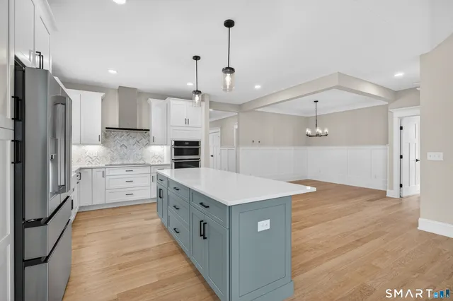 a kitchen with kitchen island a sink stainless steel appliances and cabinets