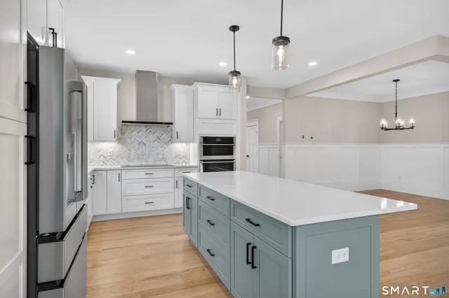 a kitchen with white cabinets and stainless steel appliances