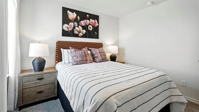 a bedroom with a bed and painting on the wall