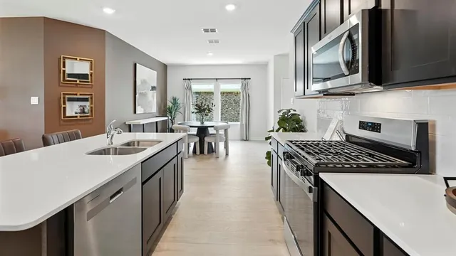 a kitchen with sink stove and cabinets