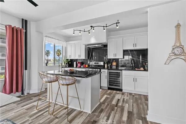 a kitchen with kitchen island granite countertop a sink cabinets and stainless steel appliances