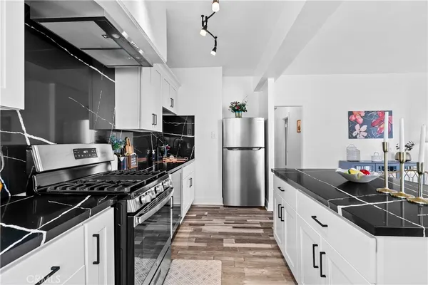 a kitchen with stainless steel appliances a sink stove and refrigerator