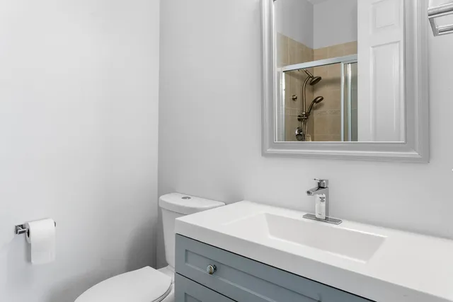 a bathroom with a toilet a sink and mirror