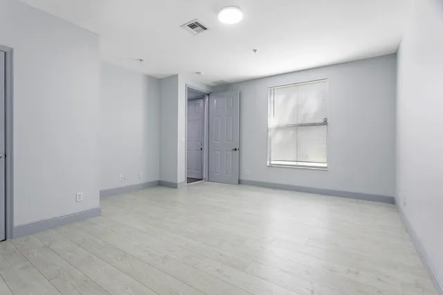 an empty room with windows and closet