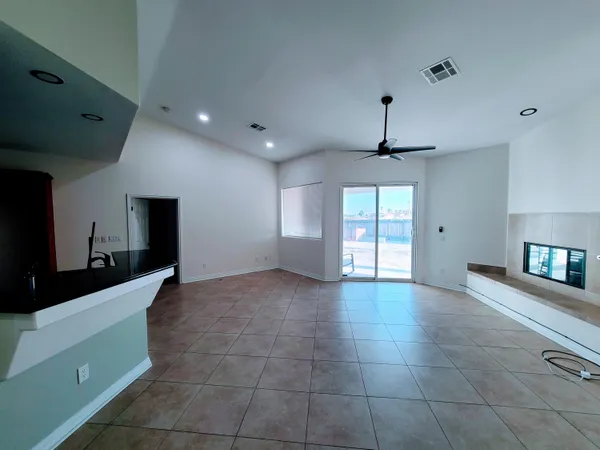 a view of an empty room with window and cabinet