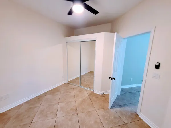 an empty room with closet and chandelier fan