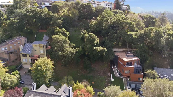 an aerial view of residential houses with outdoor space and trees
