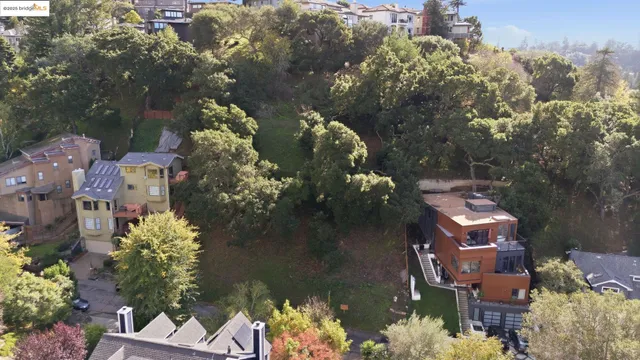 an aerial view of residential houses with outdoor space and trees