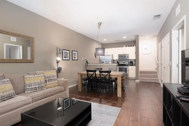 a living room with furniture kitchen view and a dining table
