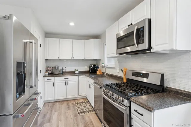 a kitchen with stainless steel appliances granite countertop a stove microwave sink and refrigerator