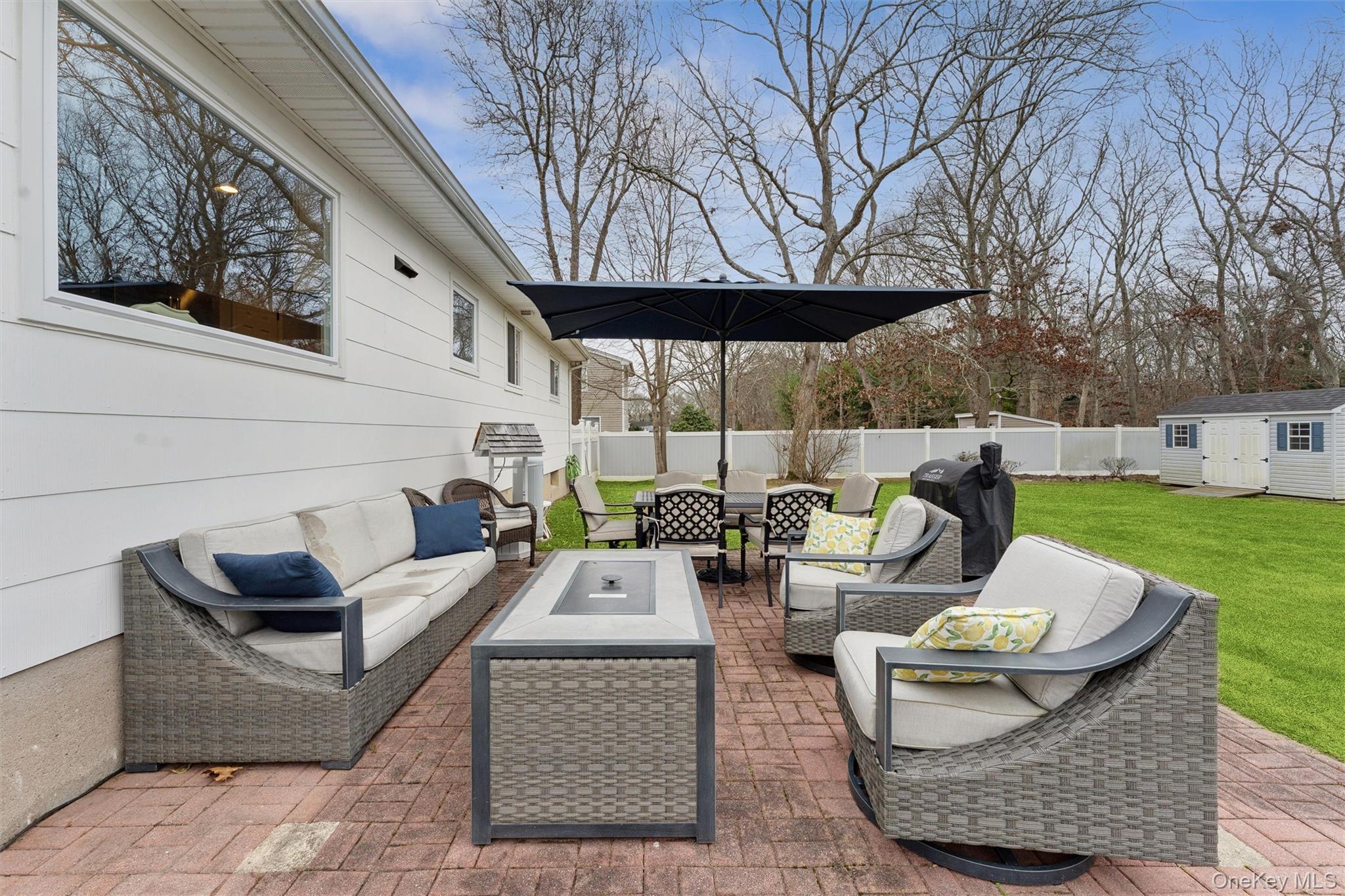 31 Howell Place Speonk, NY 11972 - Photo 7 of 16 Fenced backyard featuring a patio area, grilling area, outdoor lounge area, and a storage unit