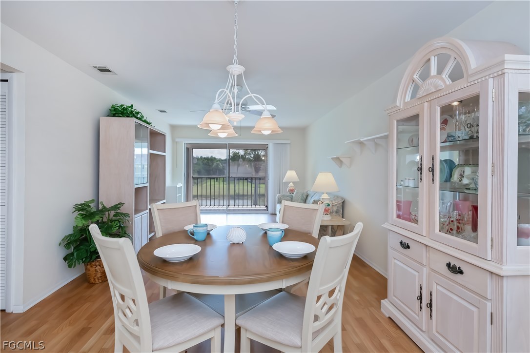 1100 Pondella Road, Unit 514 Cape Coral, FL 33909 - Photo 9 of 34 a view of a dining room with furniture wooden floor and chandelier