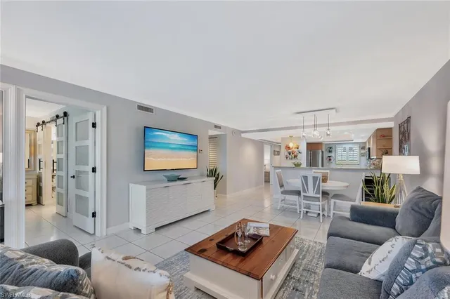 a living room with furniture and view of kitchen