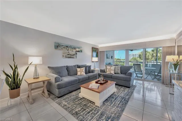 a living room with furniture potted plant and a large window