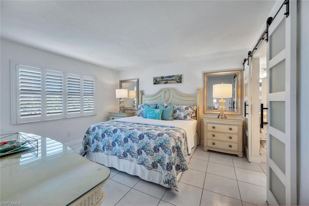 12945 Vanderbilt Drive, Unit 304 Naples, FL 34110 - Photo 23 of 45 a bedroom with a bed and a dresser