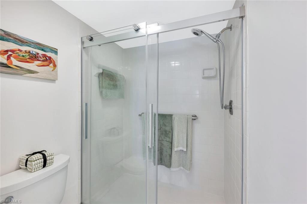 12945 Vanderbilt Drive, Unit 304 Naples, FL 34110 - Photo 27 of 45 a bathroom with a shower and a sink